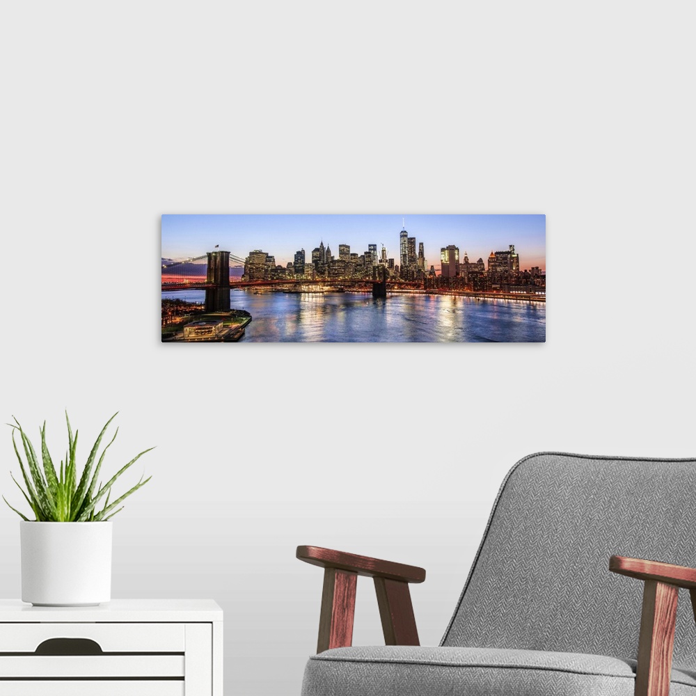 A modern room featuring View of the New York City skyline illuminated at night, with the Brooklyn Bridge, from across the...