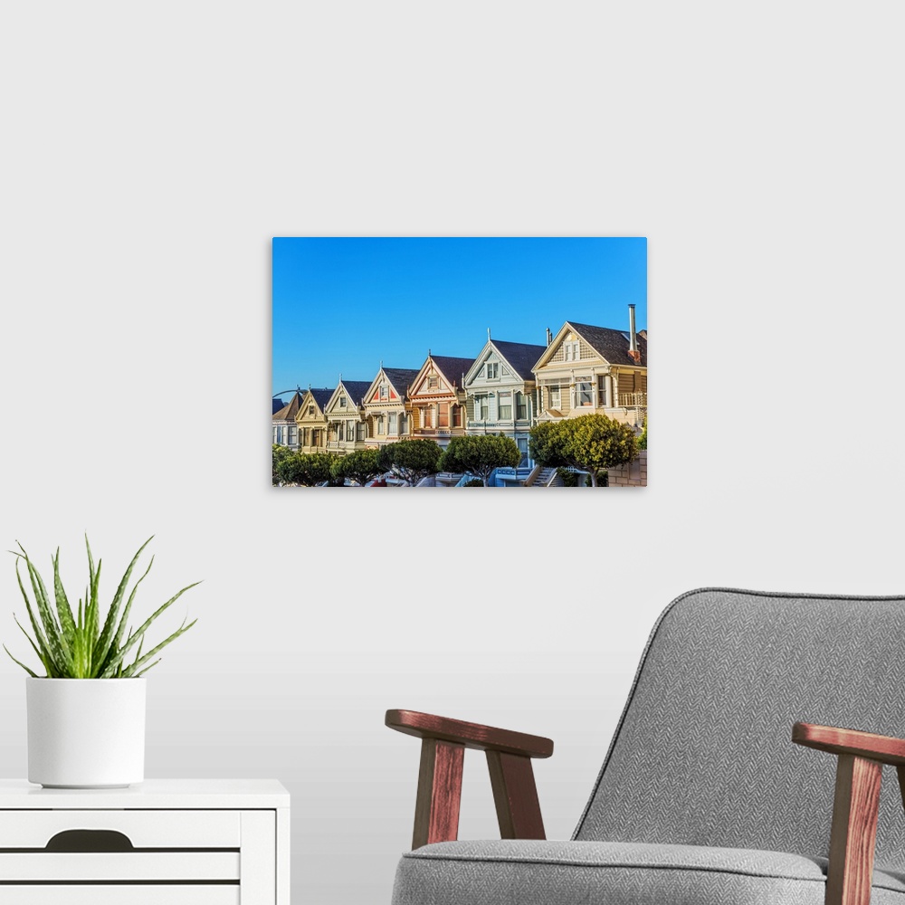 A modern room featuring Photograph of the Painted Ladies in downtown San Francisco with a bright blue sky above.