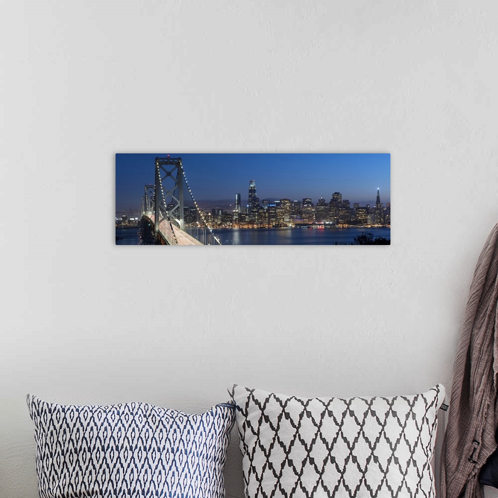 A bohemian room featuring Panoramic photograph of the Bay Bridge and the San Francisco skyline lit up at dusk.