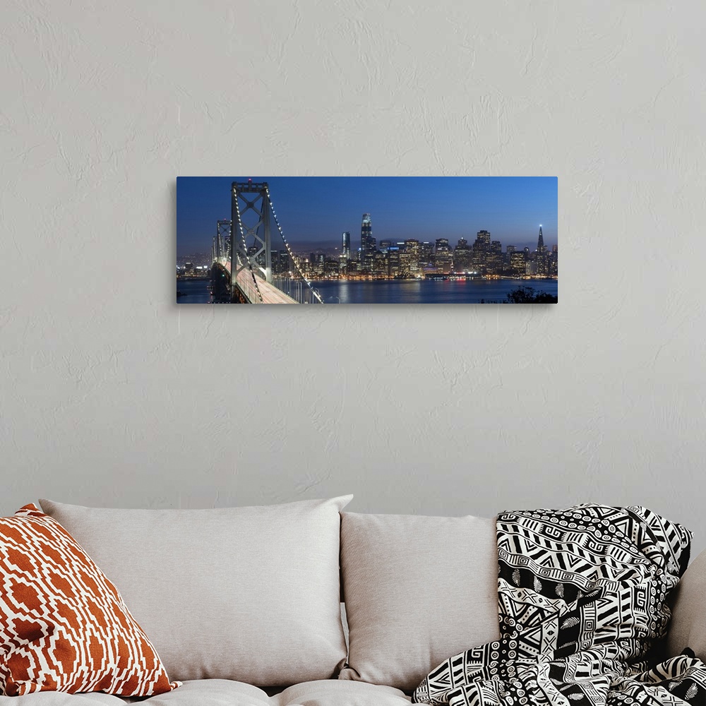 A bohemian room featuring Panoramic photograph of the Bay Bridge and the San Francisco skyline lit up at dusk.