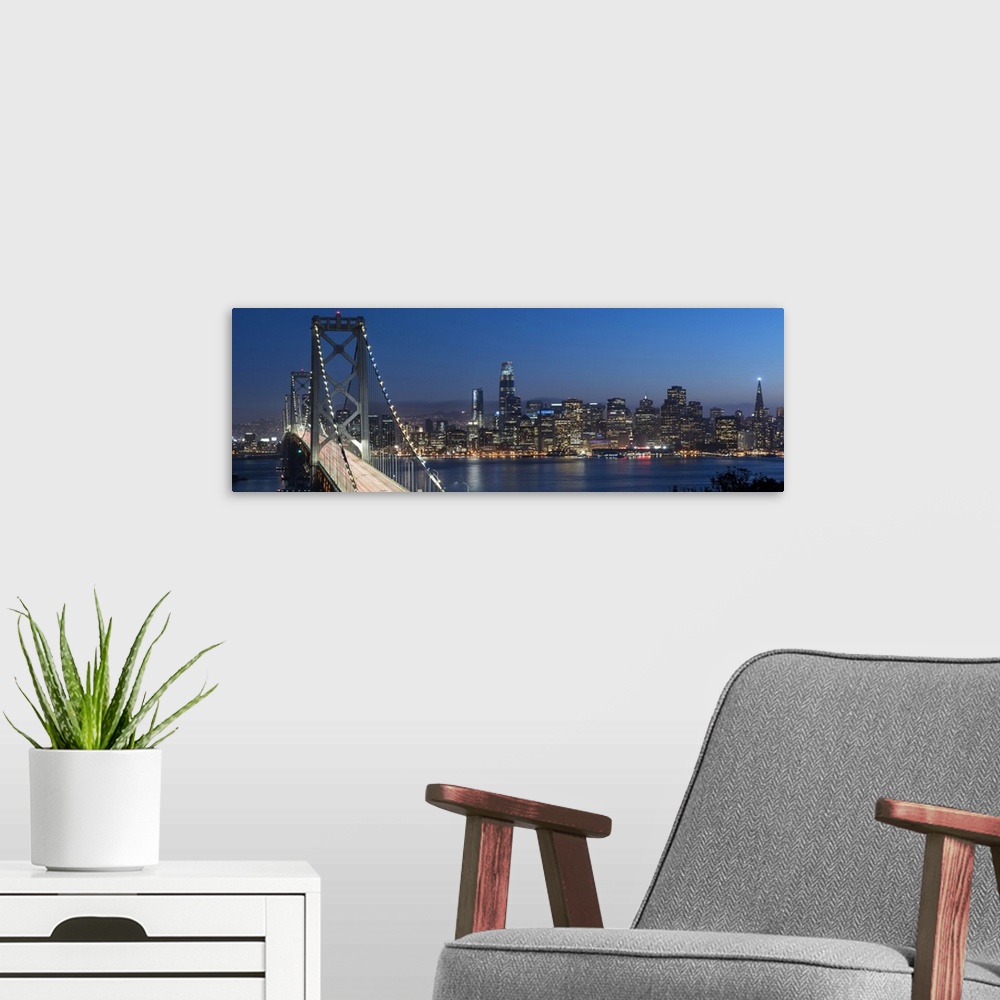 A modern room featuring Panoramic photograph of the Bay Bridge and the San Francisco skyline lit up at dusk.