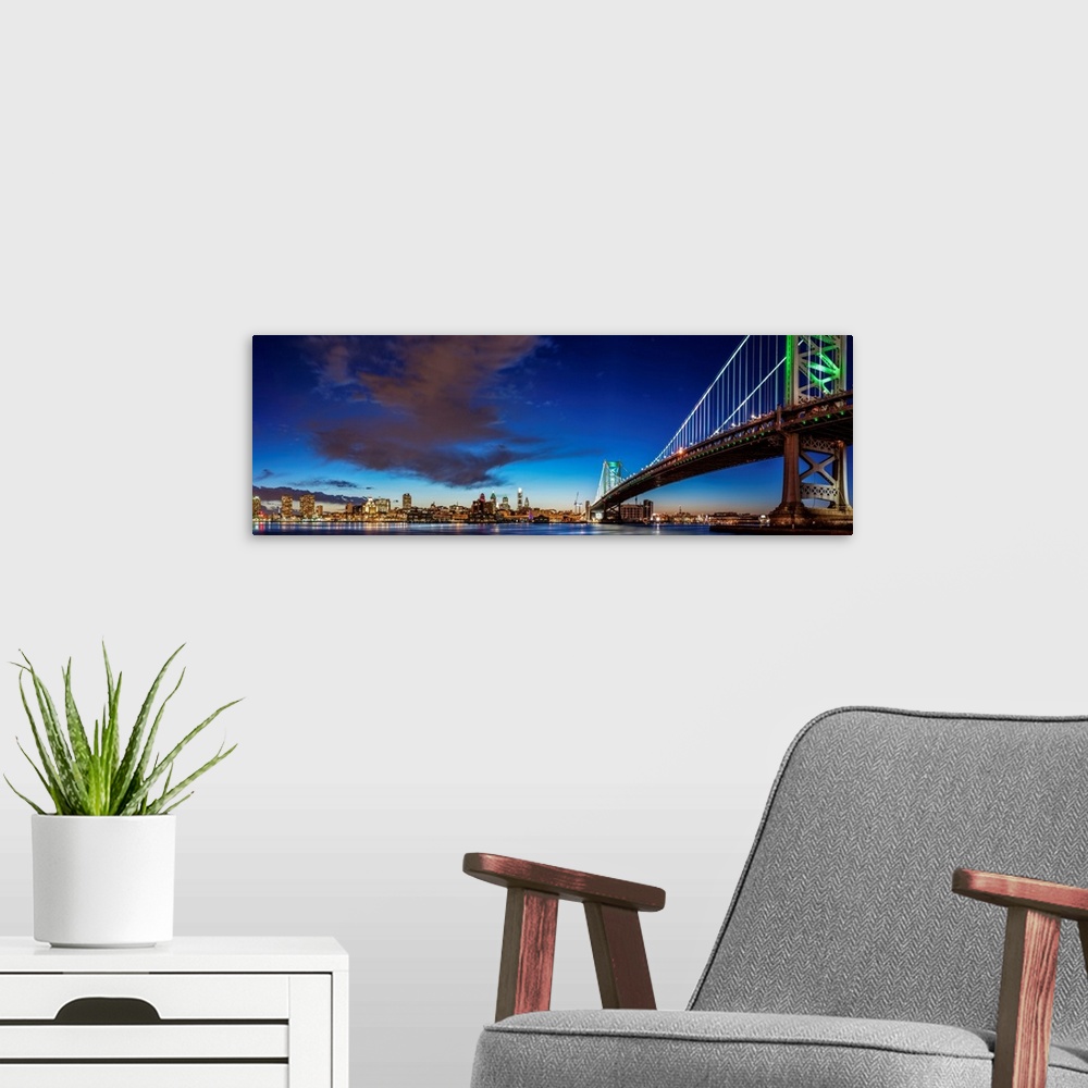 A modern room featuring Panoramic view of Philadelphia city skyline at night with Ben Franklin Bridge.