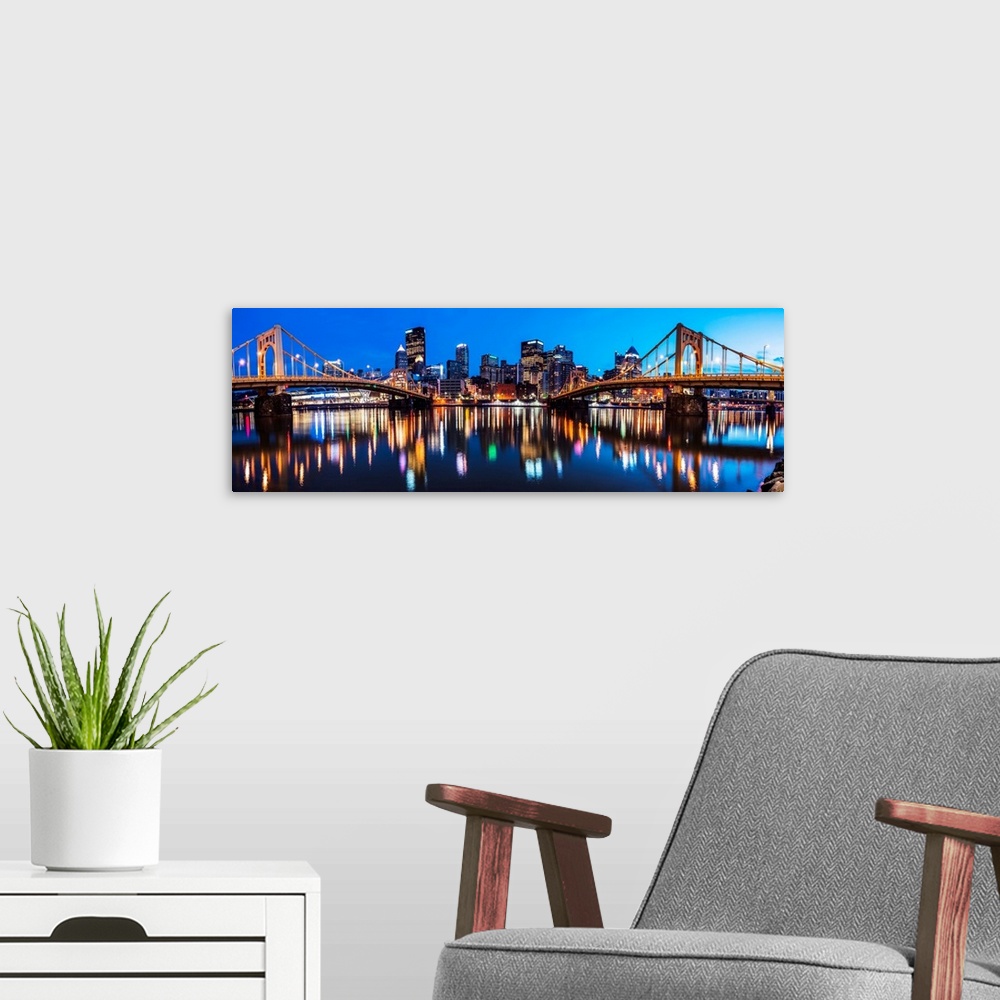 A modern room featuring Panoramic photo of downtown Pittsburgh at night with the Rachel Carson Bridge and the Andy Warhol...