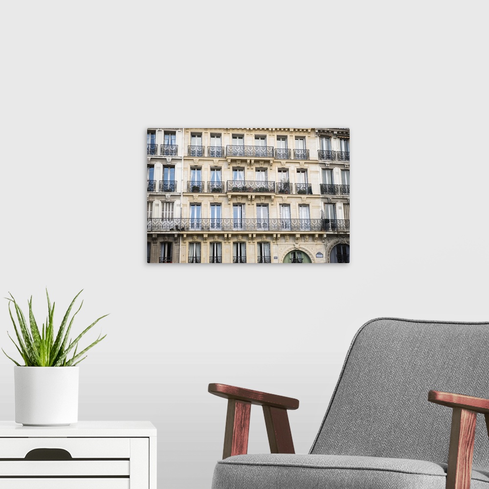 A modern room featuring Photograph of a Parisian building with rows of windows and unique railings.