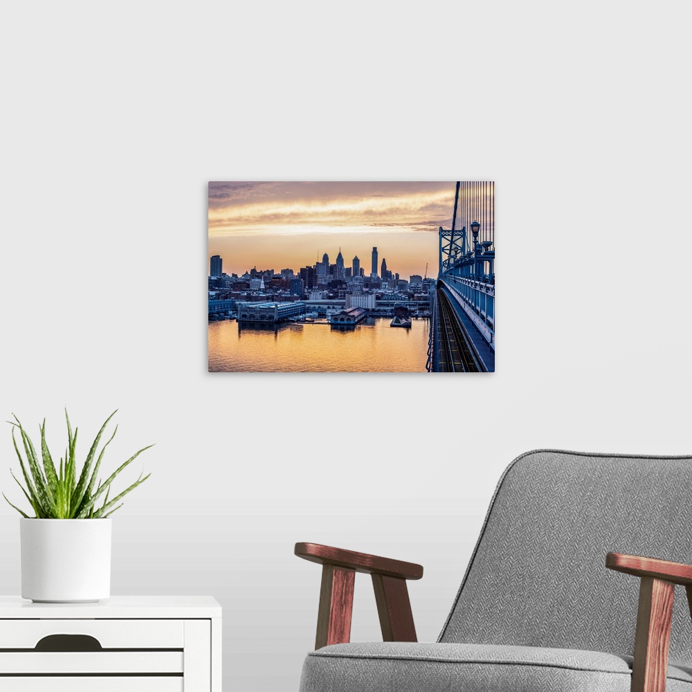 A modern room featuring View of Philadelphia's city skyline against a dewy melon colored sky.