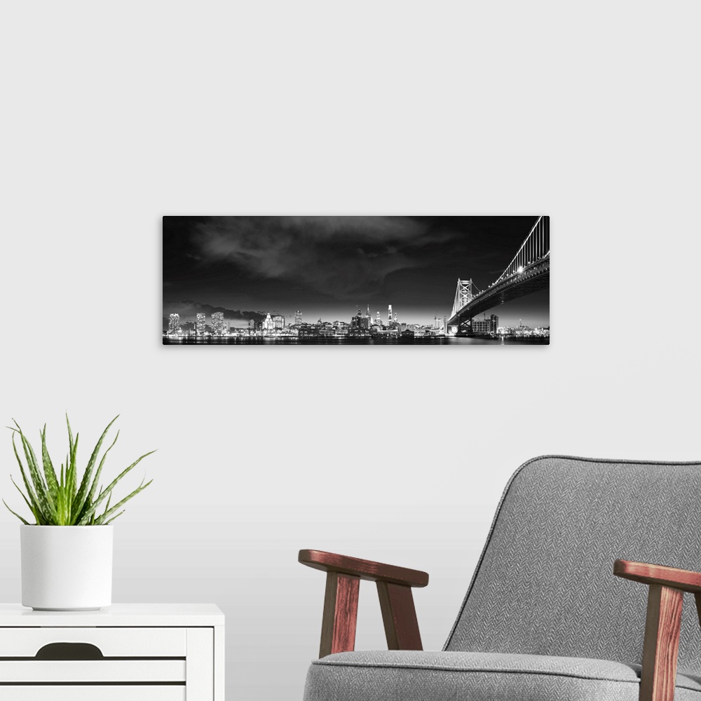 A modern room featuring Panoramic photo of the Philadelphia city skyline at night, with the Benjamin Franklin Bridge on t...