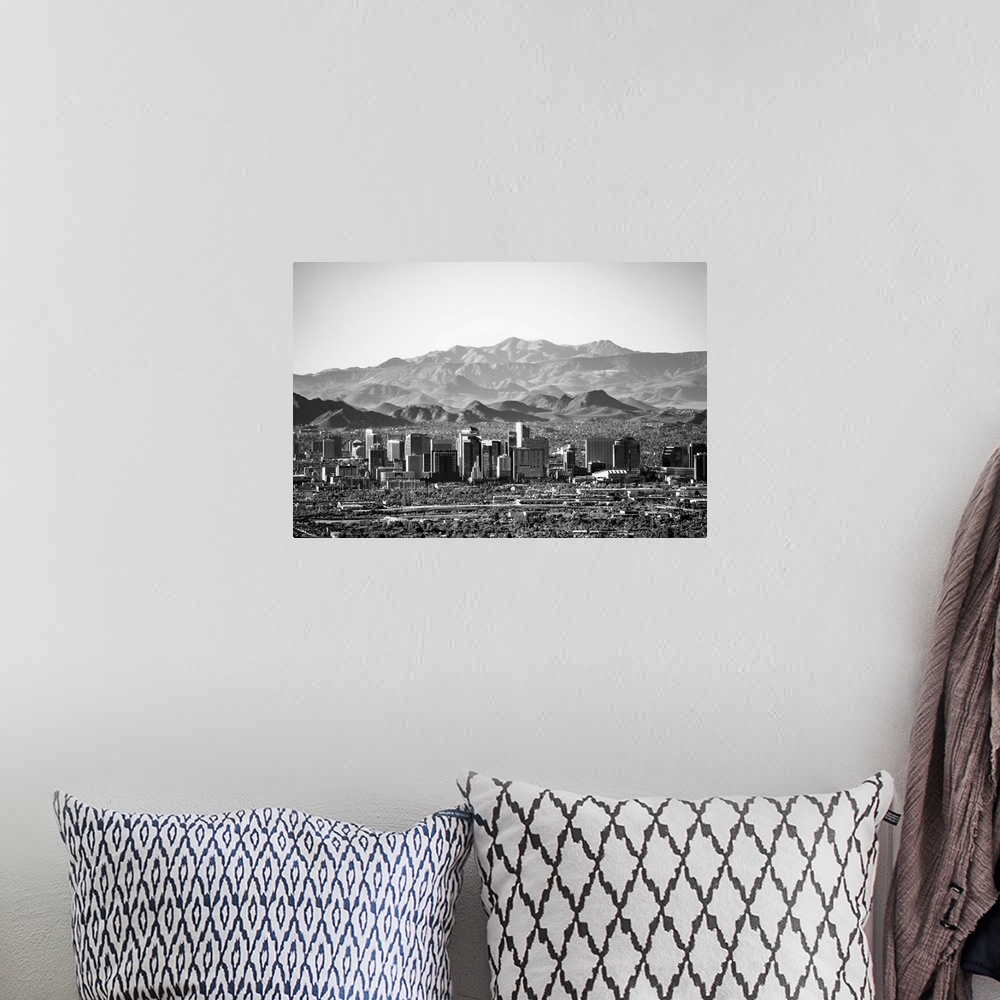 A bohemian room featuring Photograph of the Phoenix, Arizona skyline with hazy desert mountains in the background.