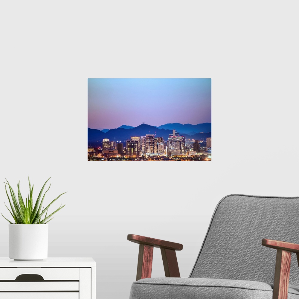 A modern room featuring Photograph of a colorful sunset over the Phoenix, Arizona skyline with silhouetted mountains in t...