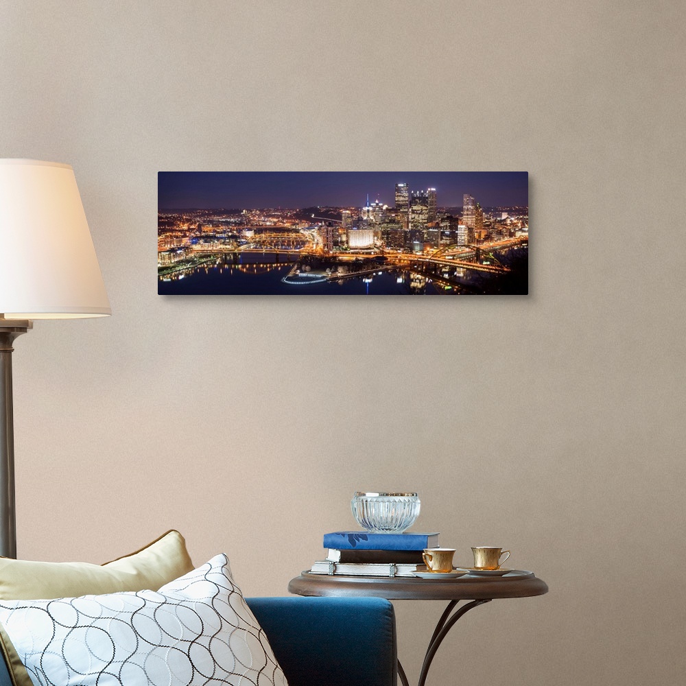 A traditional room featuring Panoramic photo of the city of Pittsburgh illuminated at night, with Point State Park in the fore...