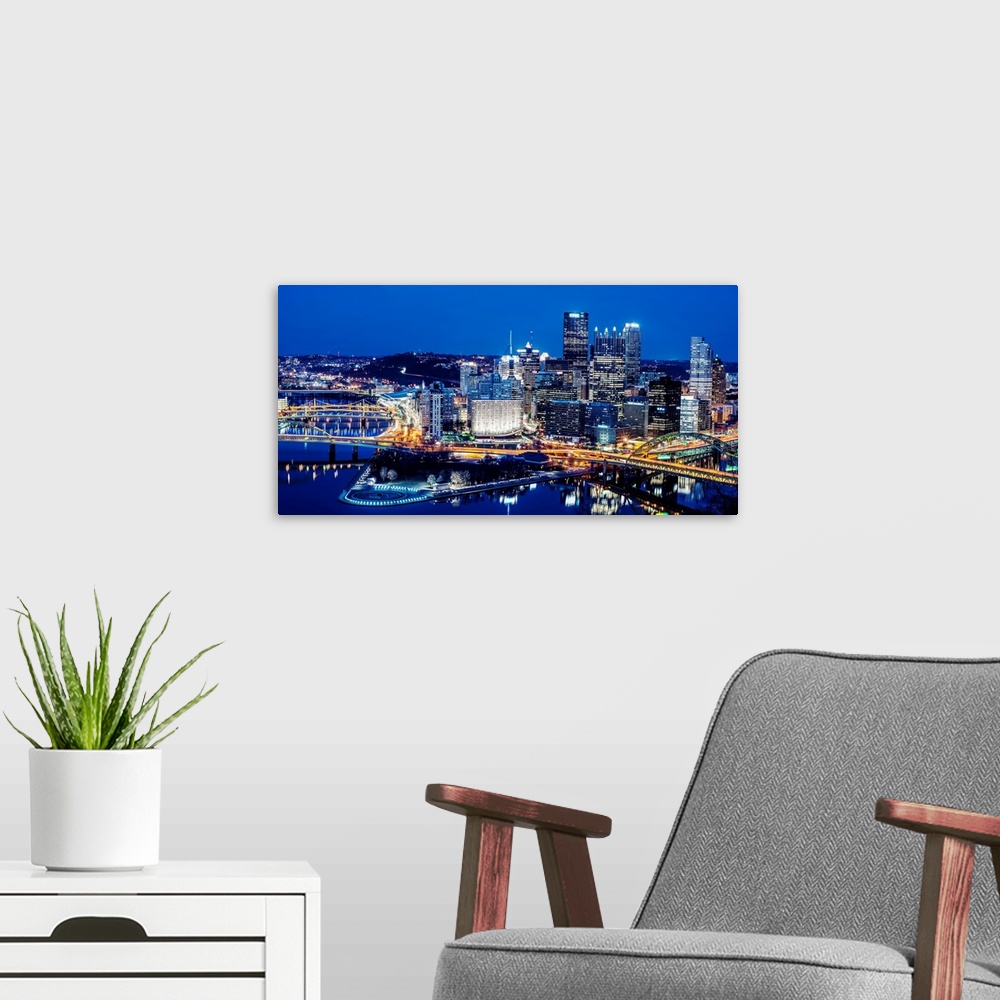 A modern room featuring Photo of downtown Pittsburgh at night with Point State park.