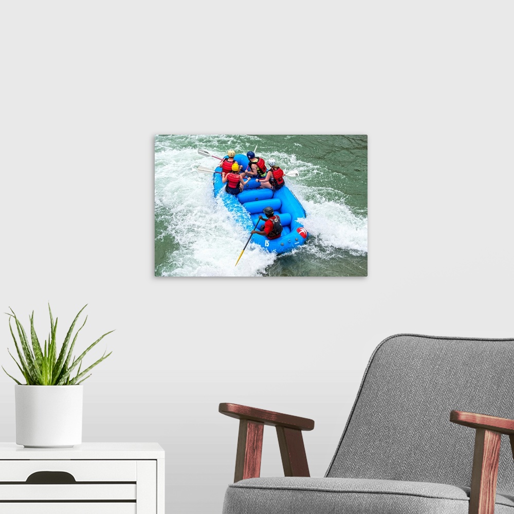 A modern room featuring A raft filled with people float in whitewater rapids.