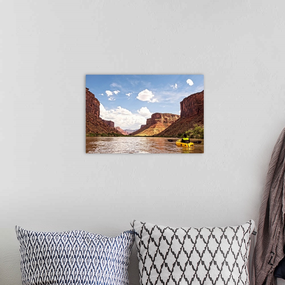 A bohemian room featuring Tall sandstone cliffs tower along the edge of the Colorado River, with clouds and blue skies over...