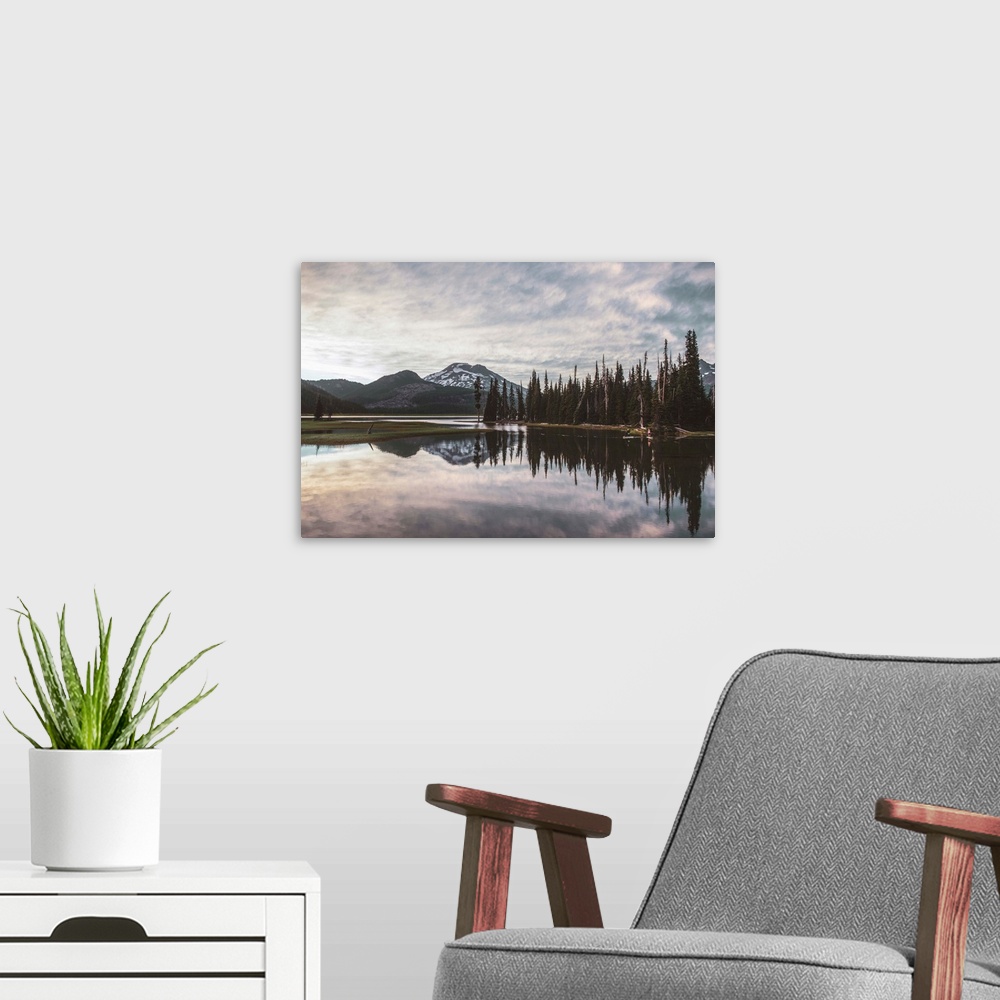 A modern room featuring View of trees reflecting in Sparks Lake on a cloudy day in Deschutes National Forest, Oregon.
