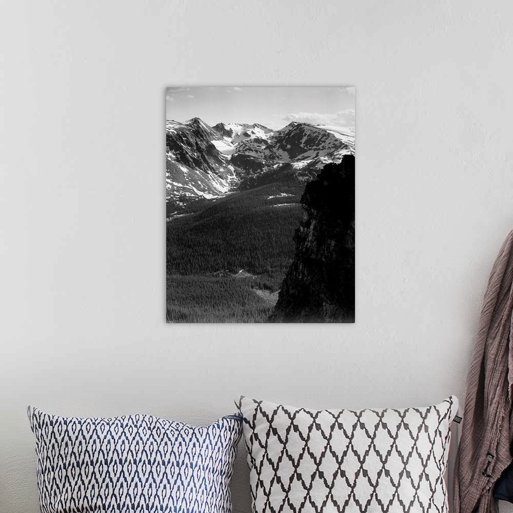 A bohemian room featuring In Rocky Mountain National Park, vertical panorama of snow-capped mountain timbered area below.