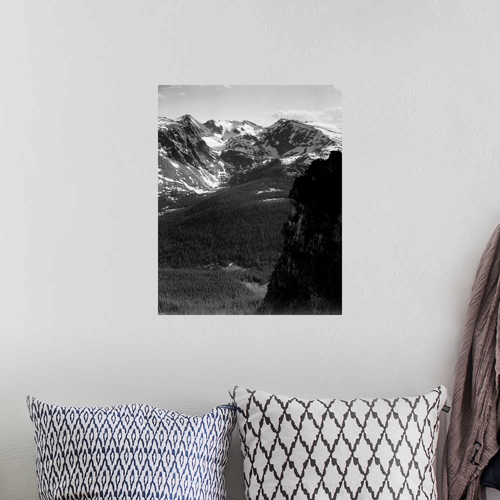 A bohemian room featuring In Rocky Mountain National Park, vertical panorama of snow-capped mountain timbered area below.