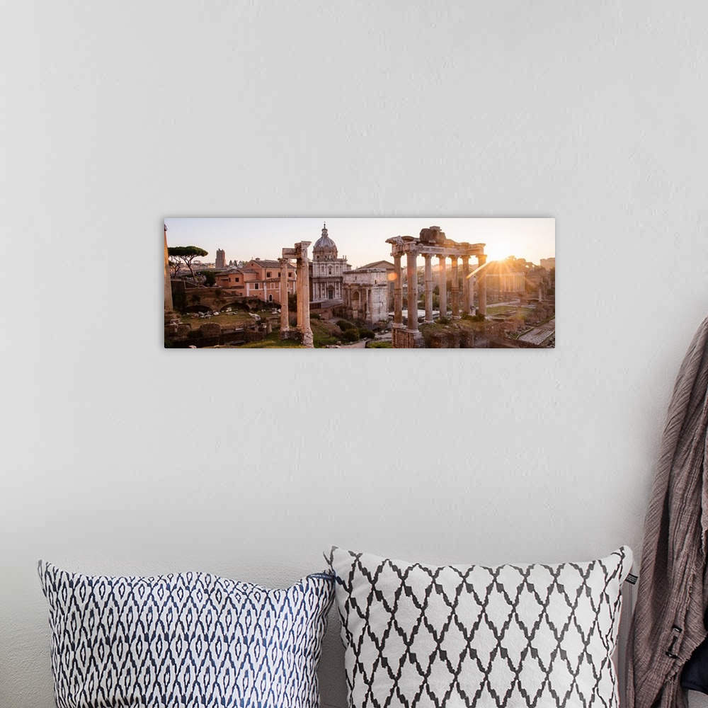 A bohemian room featuring Panoramic photograph of the ruins at the Roman Forum with the sun shining in the background.