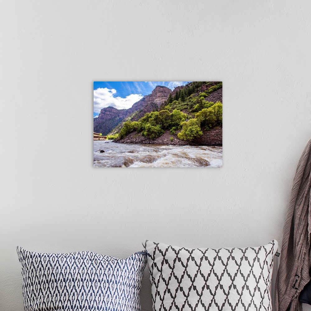 A bohemian room featuring Photo of a rushing river under a mountain cliffside in Colorado.
