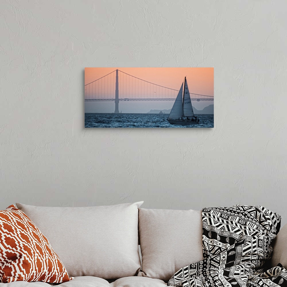 A bohemian room featuring Sunset photograph of a sailboat on the San Francisco Bay with the Golden Gate Bridge in the backg...