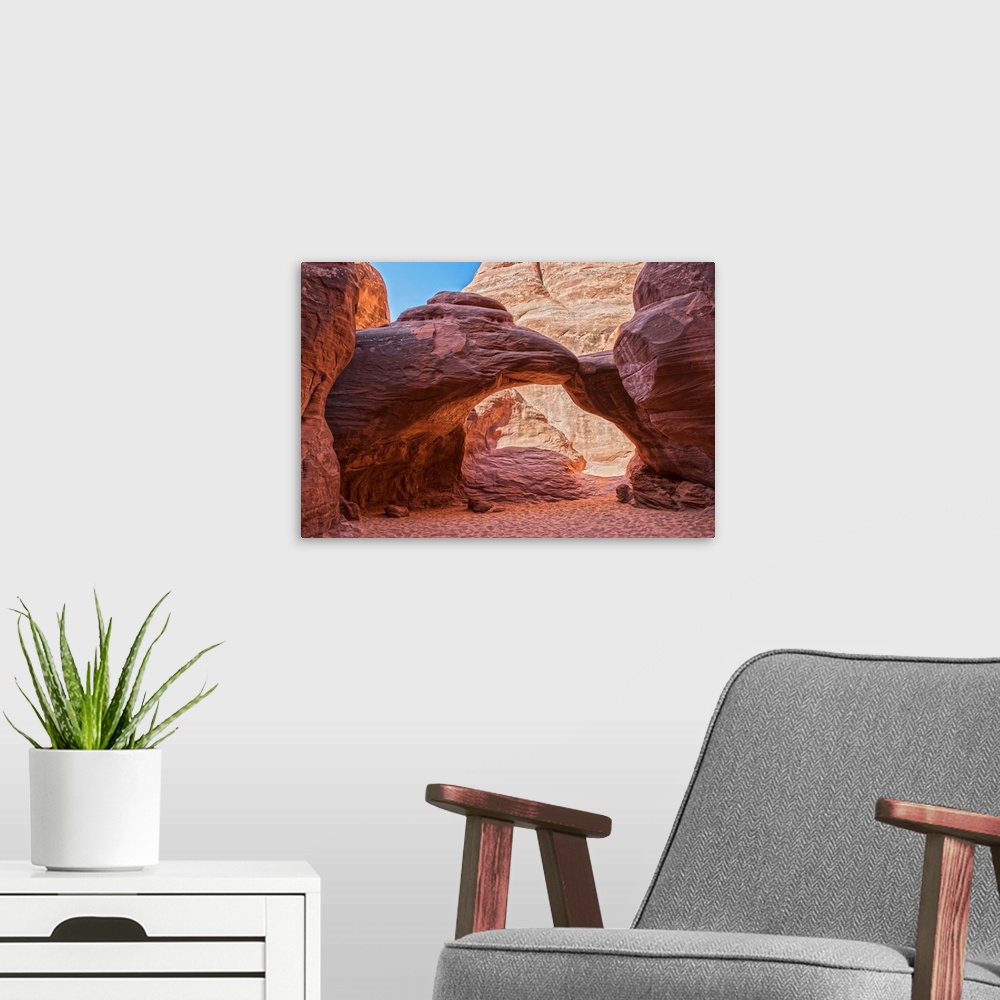 A modern room featuring Sunlight illuminates the red sandstone of the Sand Dune Arch and the sandy trail below, Arches Na...