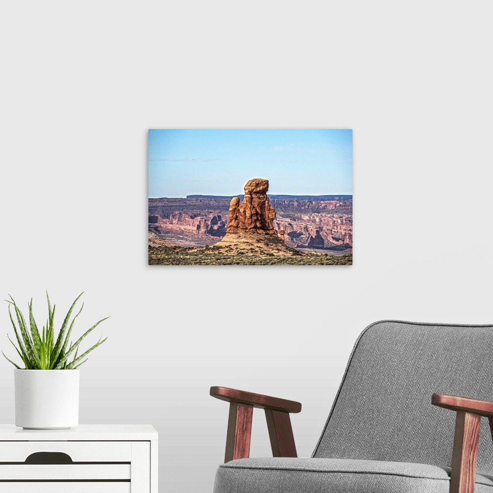 A modern room featuring Sandstone tower overlooking the canyon and desert under a pale blue sky in Arches National Park, ...
