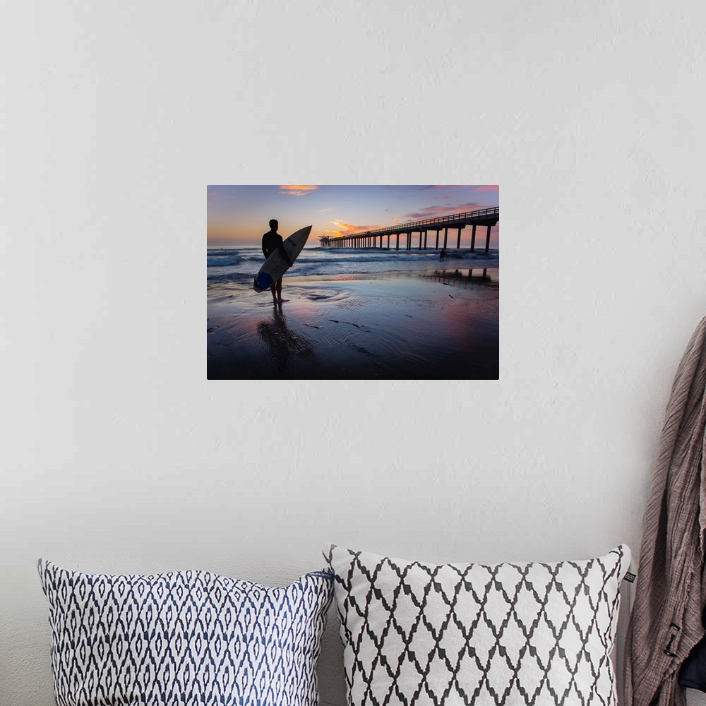 A bohemian room featuring Silhouetted photograph of a man holding a surf board on the shore of Ocean Beach in San Diego, Ca...