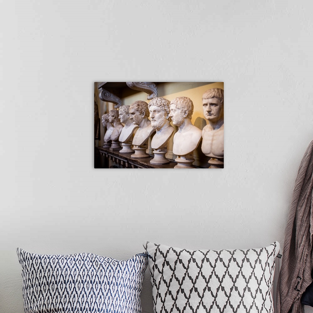 A bohemian room featuring Photograph of sculptures in a row inside the Vatican History Museum.