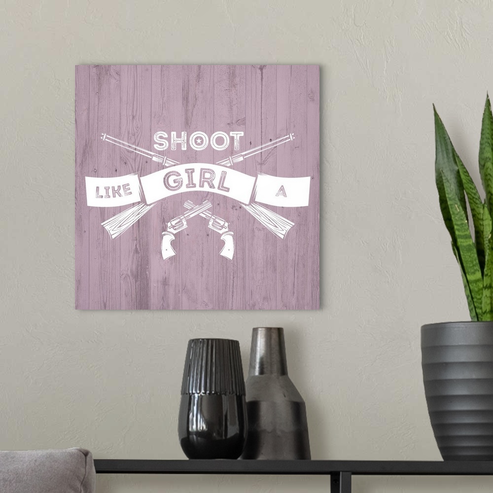 A modern room featuring Crossed pistols and rifles with a banner reading "Shoot Like A Girl" on a pink distressed wood ba...