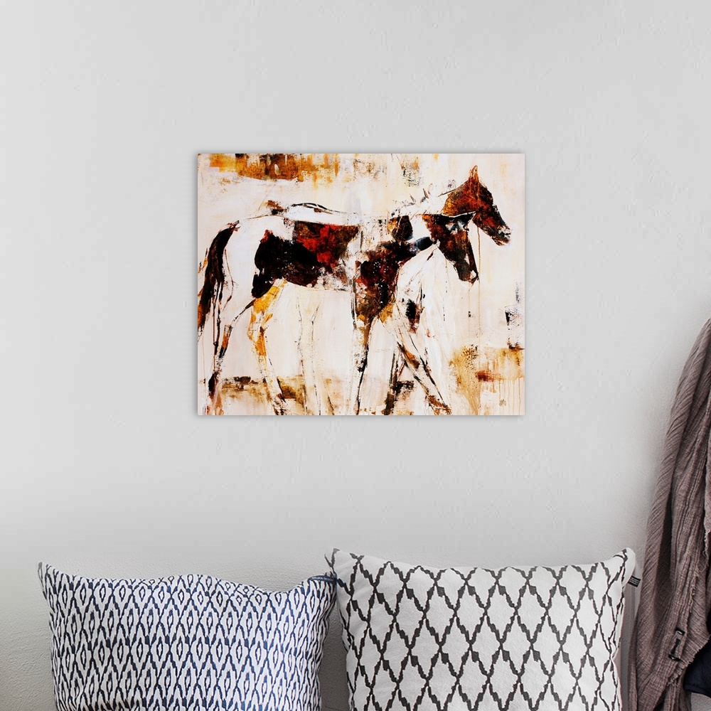 A bohemian room featuring Earth-toned portrait of two horsed standing side by side.