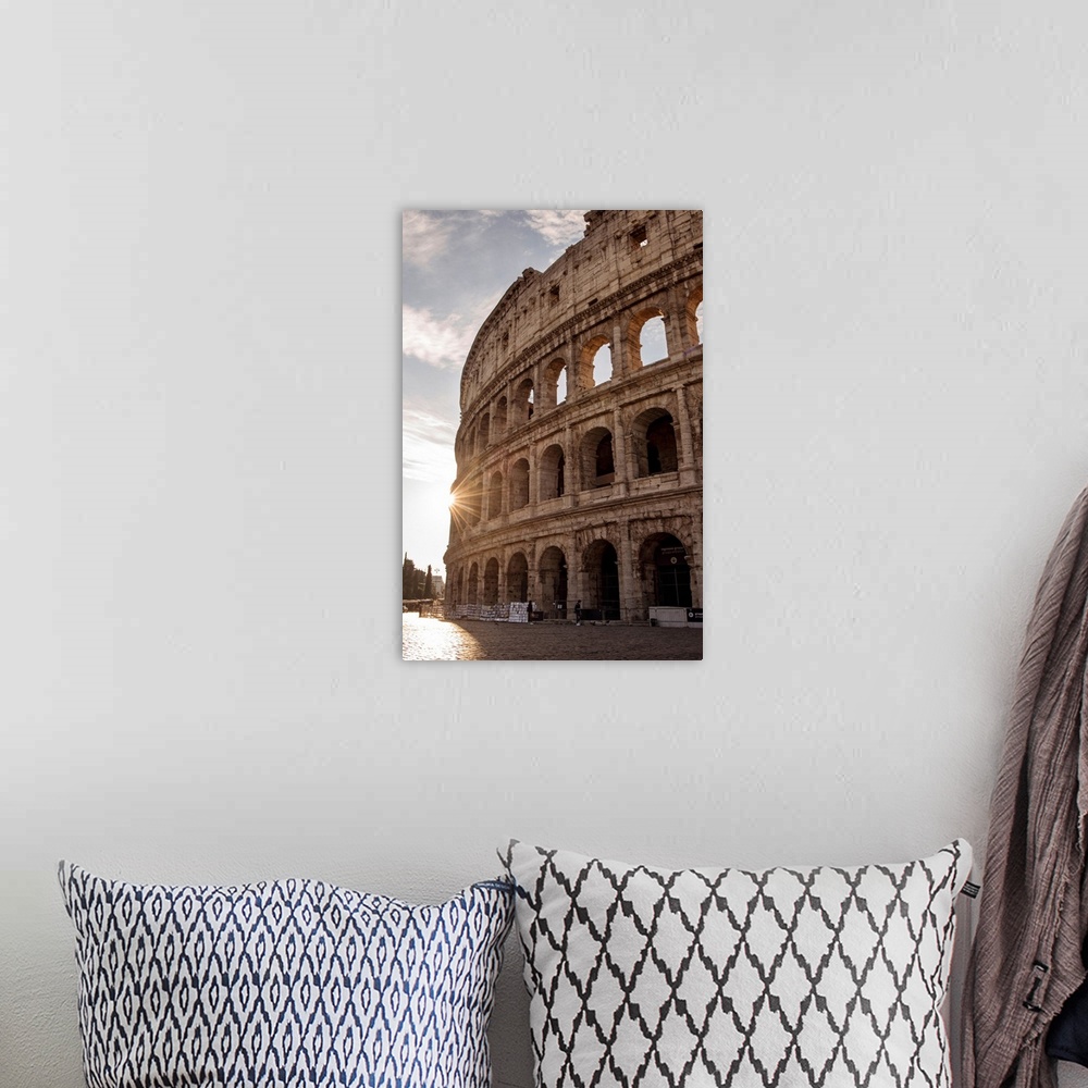 A bohemian room featuring Photograph of the sun shining on the side of the Colosseum in Rome on a beautiful day.