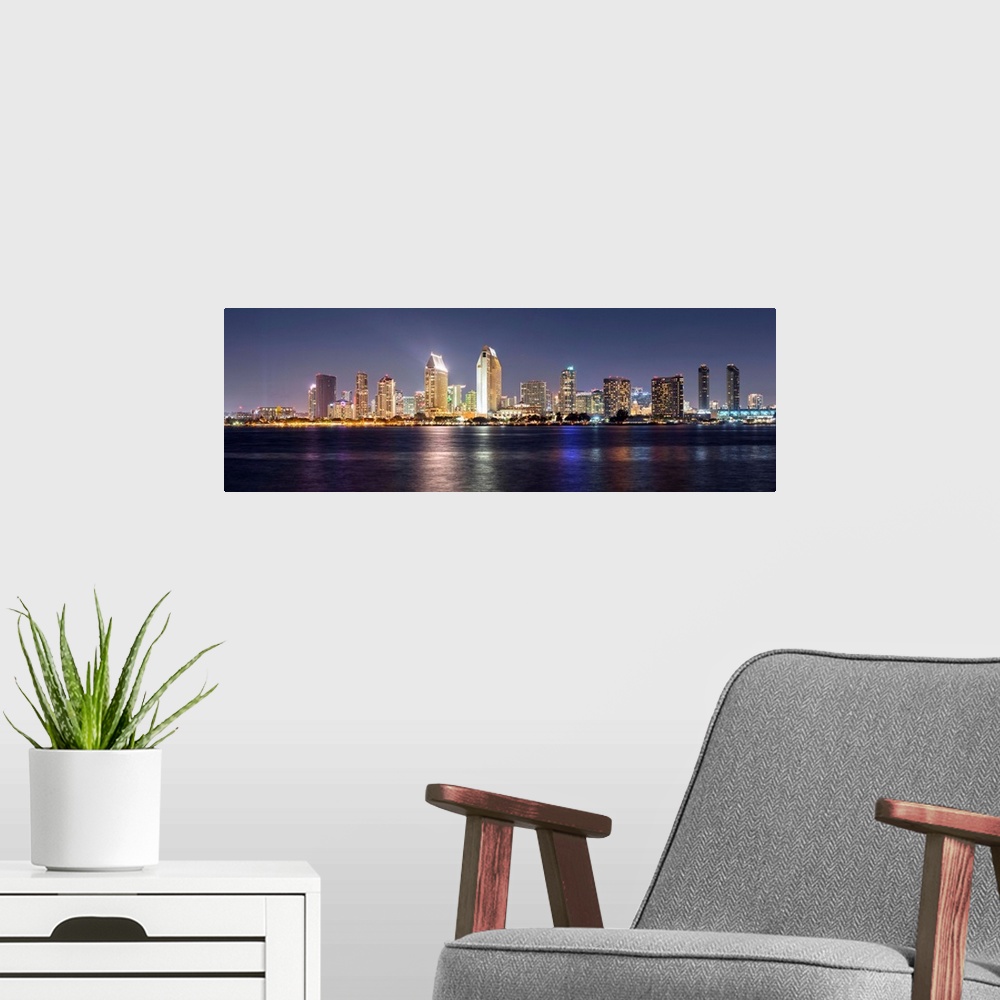 A modern room featuring Panoramic photograph of the San Diego, California skyline lit up at night from across the water.