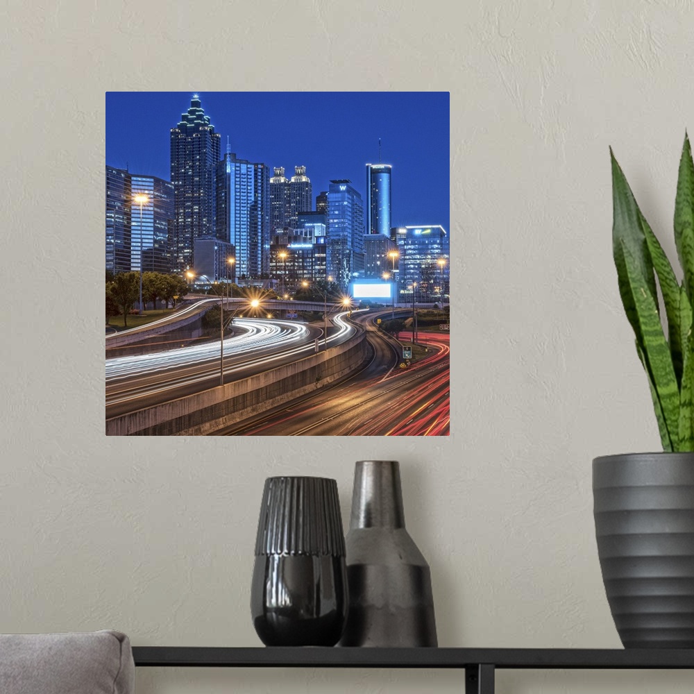 A modern room featuring City skyline of Atlanta, Georgia, illuminated night with light trails from passing traffic in the...
