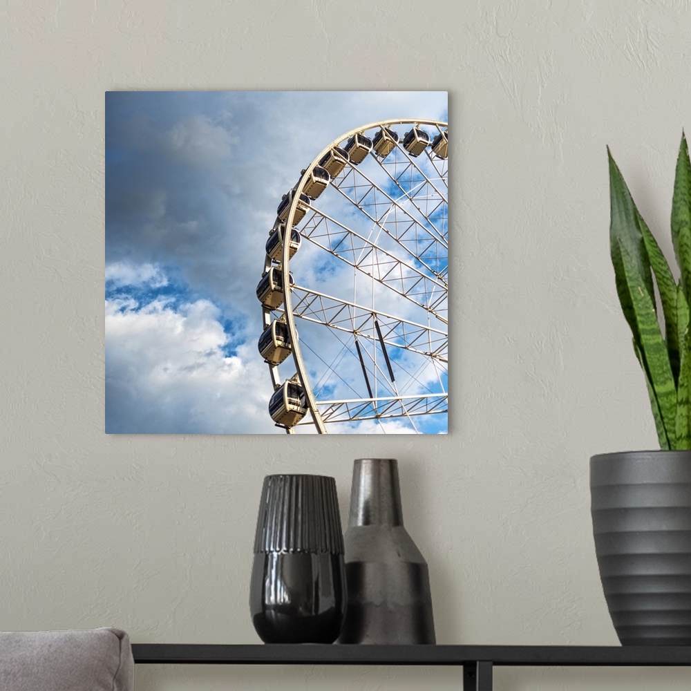 A modern room featuring The gondolas of SkyView Atlanta Ferris Wheel, a 20-story wheel, against a backdrop of clouds over...