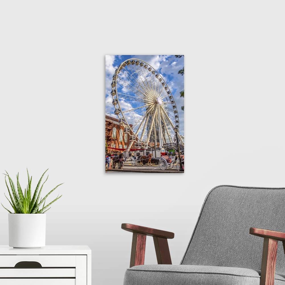 A modern room featuring SkyView Atlanta Ferris Wheel, a 20-story wheel, seen over other  recreational attractions in Cent...