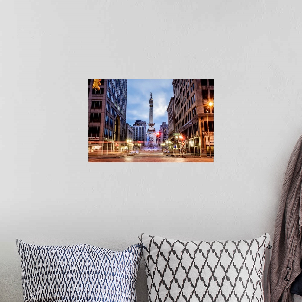 A bohemian room featuring The Soldiers and Sailors Monument in the evening with lights from passing traffic in Indianapolis...