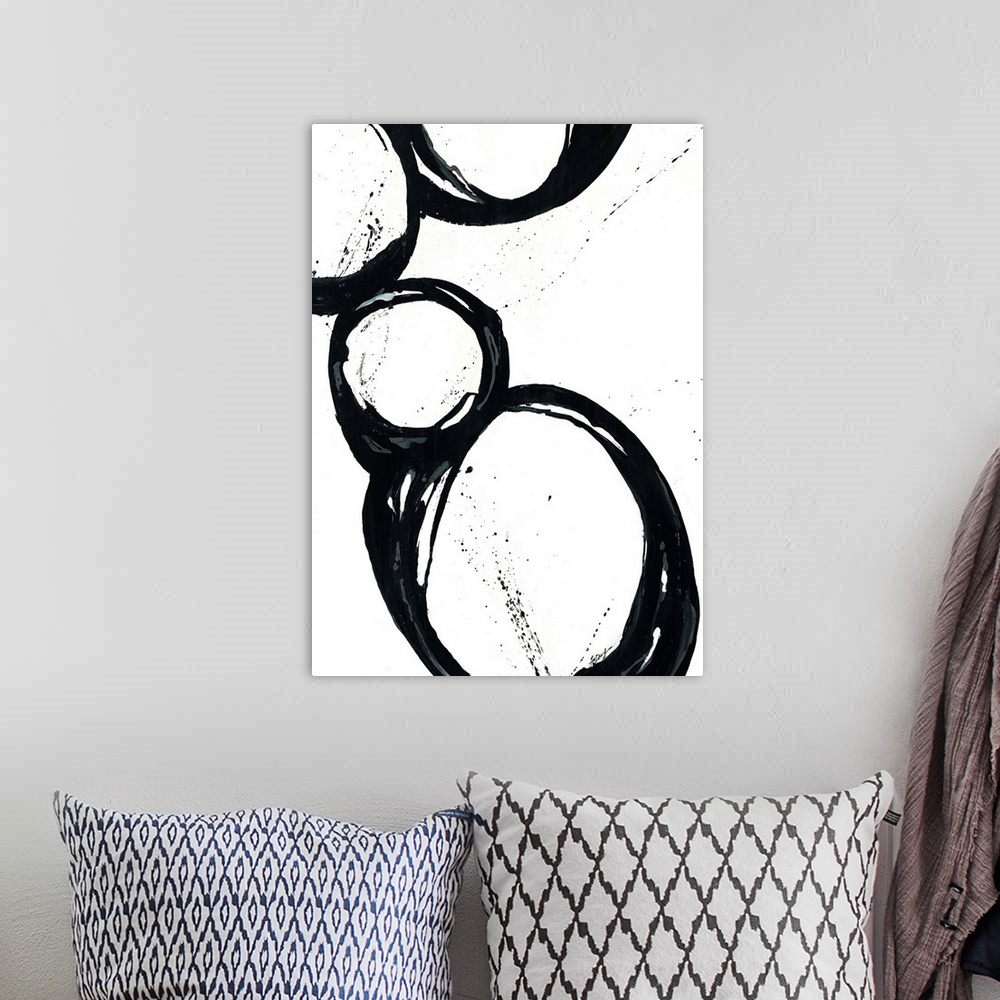 A bohemian room featuring Large vertical abstract modern artwork of different sized circular designs on a blank background.