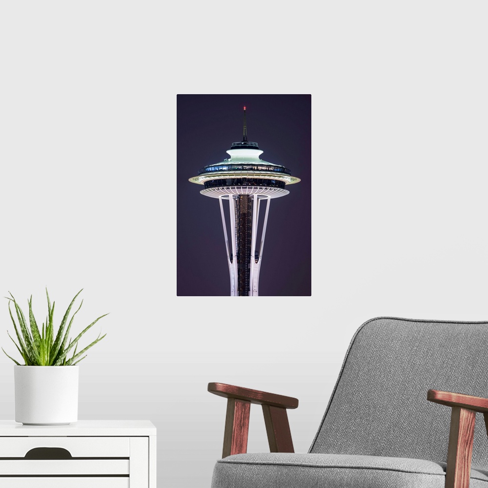 A modern room featuring Photograph of the Seattle Space Needle lit up at night with dark purple skies in the background.