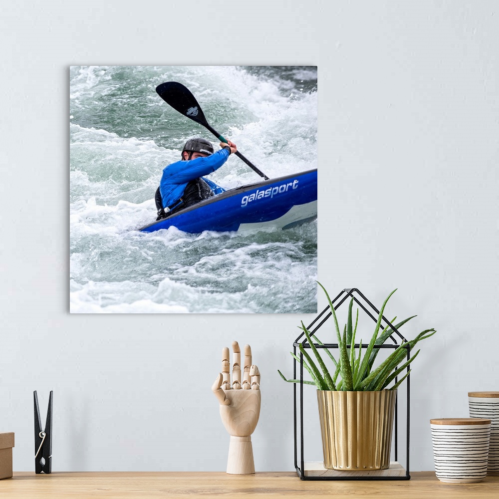 A bohemian room featuring A person paddling in a kayak in whitewater rapids.