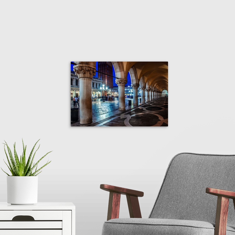 A modern room featuring Photograph of the view from underneath arches at night in St. Mark's Square, Venice.