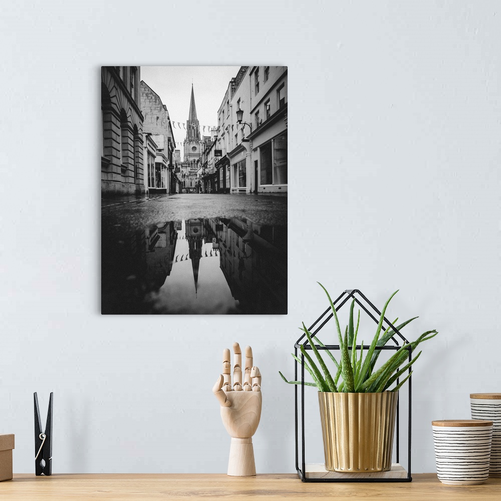 A bohemian room featuring Black and white photograph of St. Michael's Church reflecting into a puddle in the middle of a st...