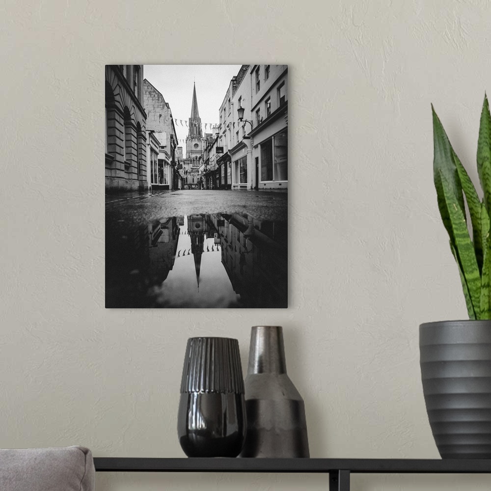 A modern room featuring Black and white photograph of St. Michael's Church reflecting into a puddle in the middle of a st...