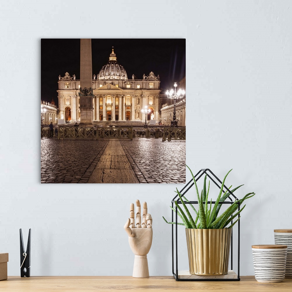 A bohemian room featuring Square photograph of St. Peter's Basilica  lit up at night.