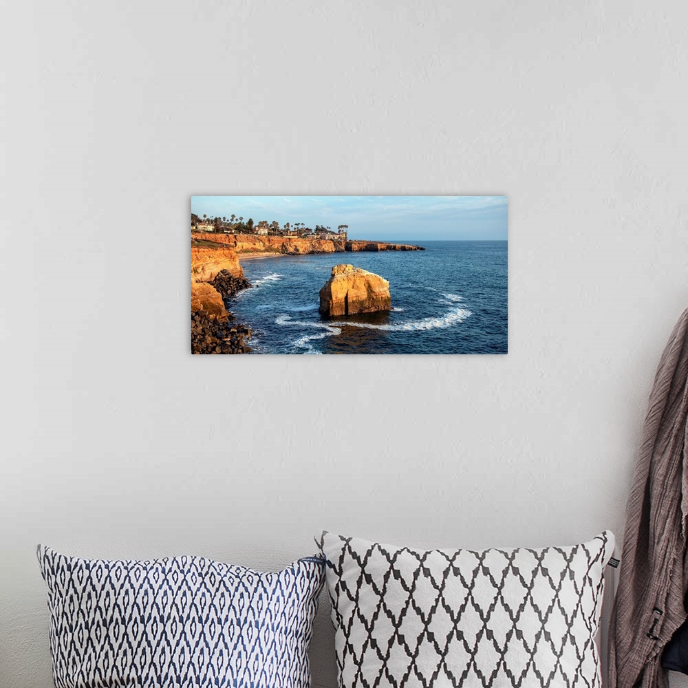 A bohemian room featuring The sun sets on a lone boulder in San Diego. The Sunset Cliffs are known for their picturesque la...