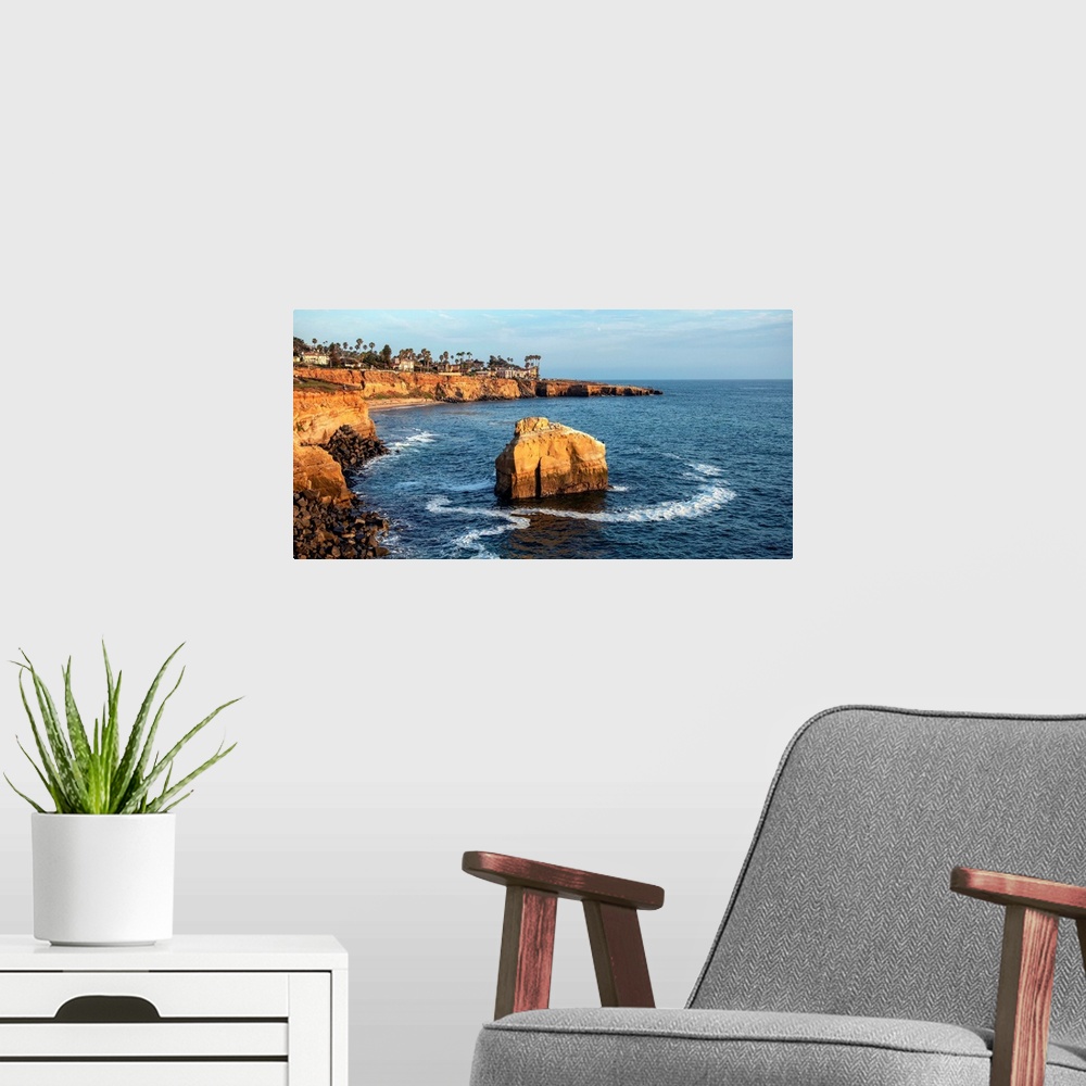 A modern room featuring The sun sets on a lone boulder in San Diego. The Sunset Cliffs are known for their picturesque la...