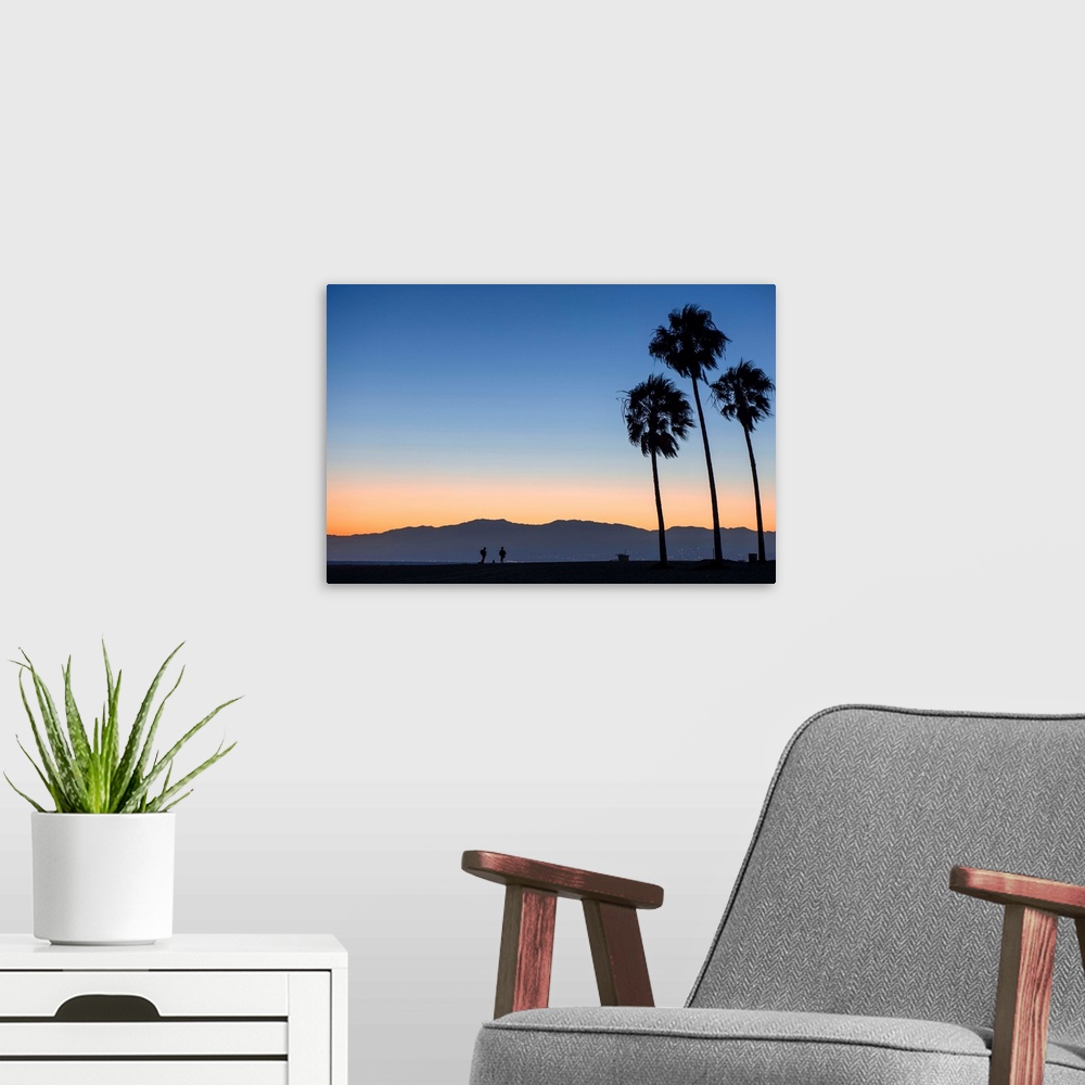 A modern room featuring The sun sets on Venice beach with the San Gabriel mountains in the background.
