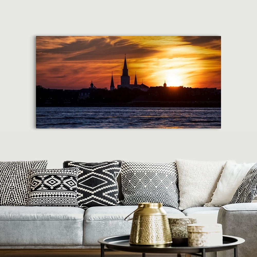 A bohemian room featuring The sun sets on the Mississippi River with view of the silhouette of St. Louis Cathedral in New O...