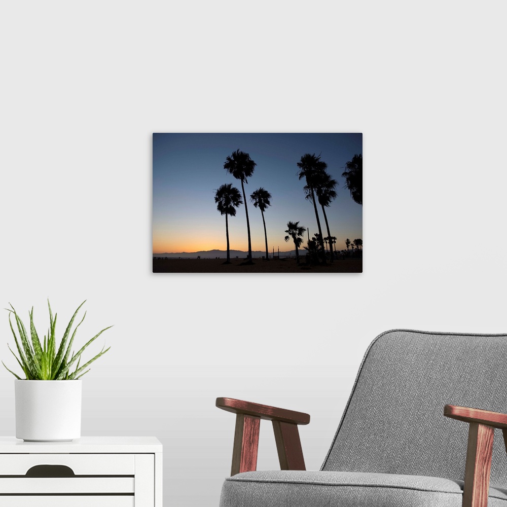 A modern room featuring The sun begins to set on Venice beach in California.