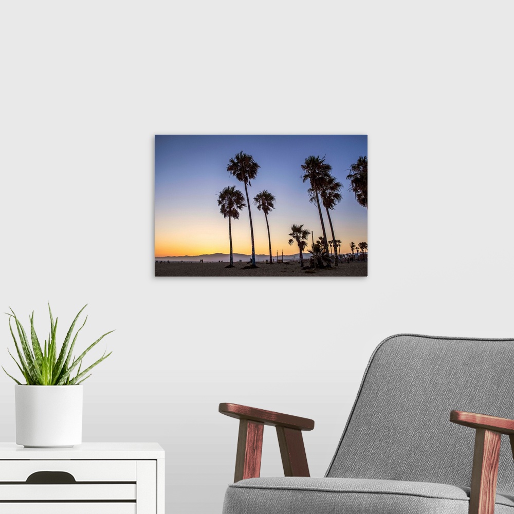 A modern room featuring The sun begins to set on Venice beach in California.