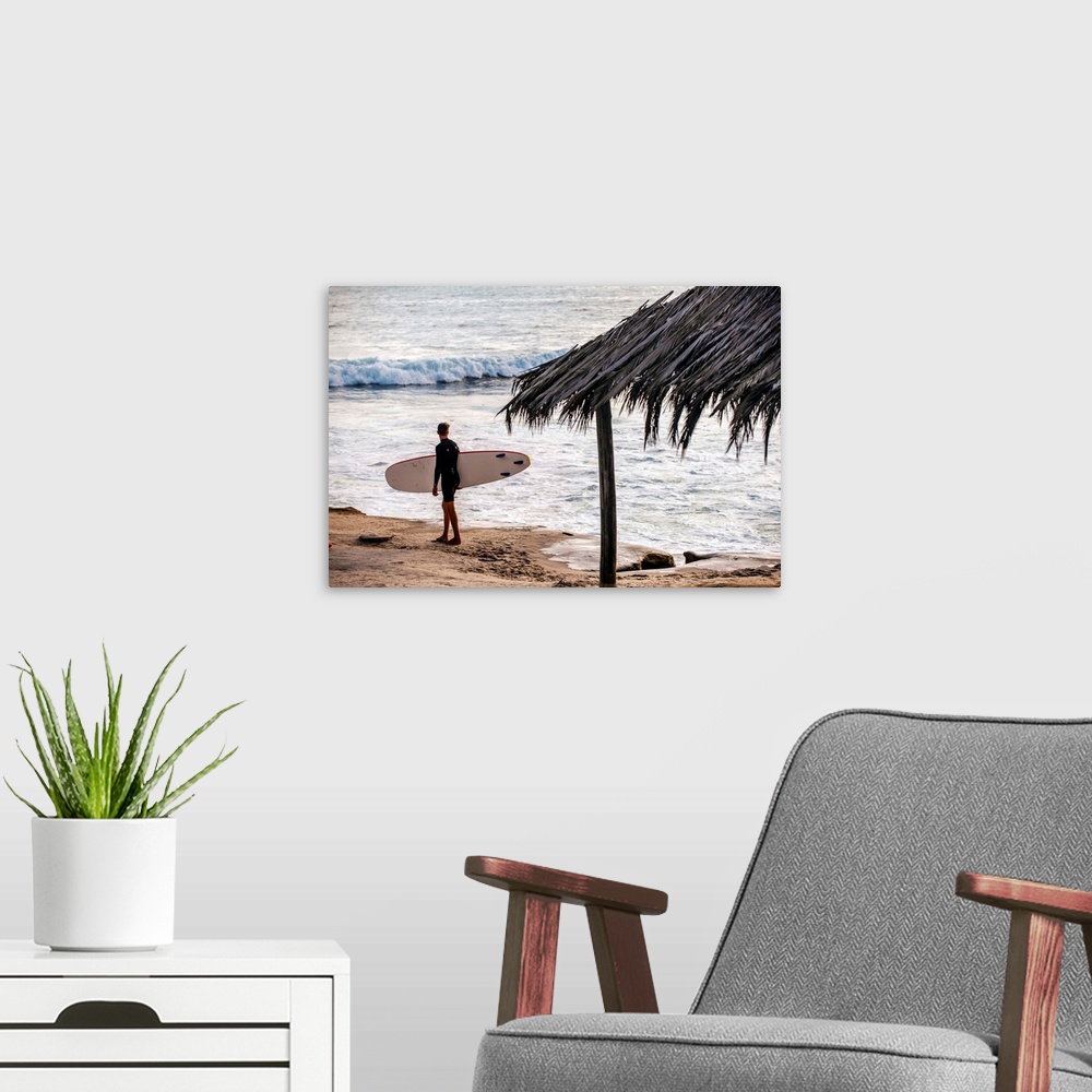 A modern room featuring Photograph of a surfer walking along the shore of the pacific ocean in San Diego, California, wit...
