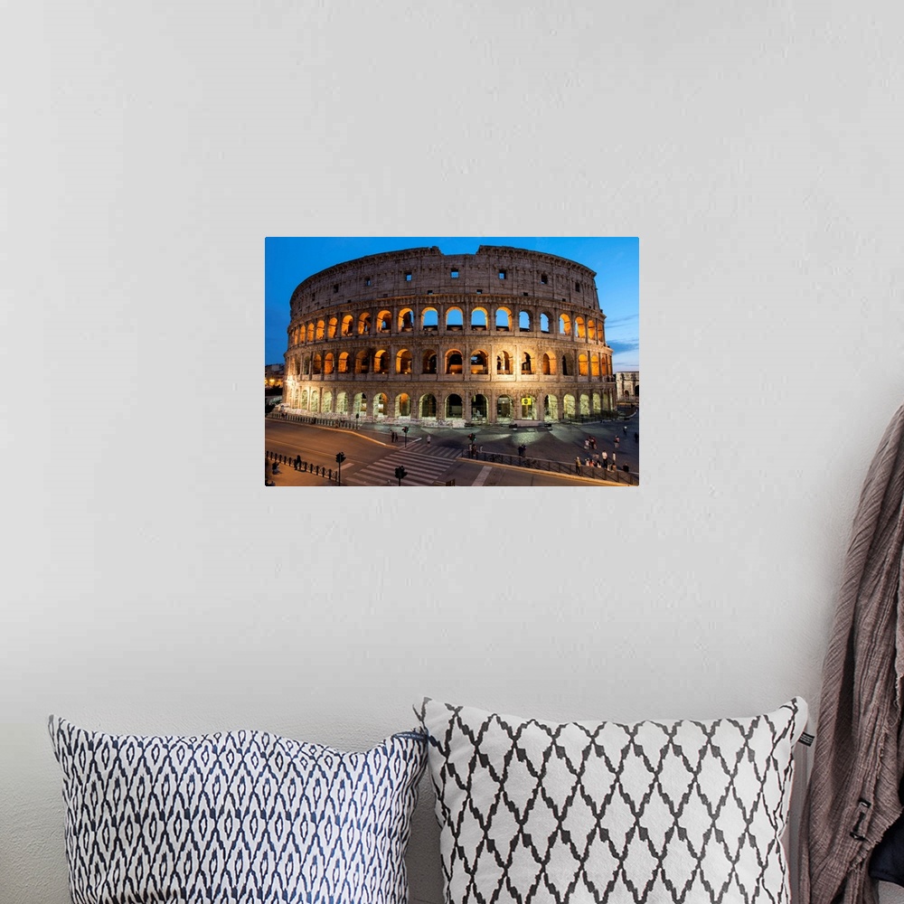 A bohemian room featuring Photograph of the Colosseum lit up at dusk.