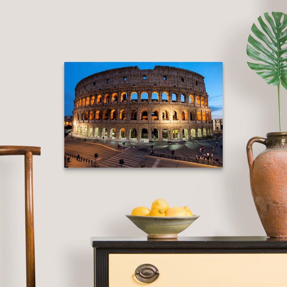 A traditional room featuring Photograph of the Colosseum lit up at dusk.